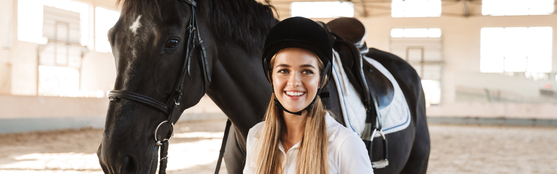 Young woman holding the rope of the horse